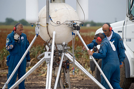 Armadillo Aerospace technicians on the launch pad performing a vehicle inspection.