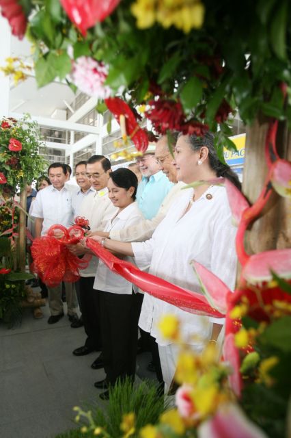 
Accompanied by national and local officials, President Gloria Macapagal-Arroyo cuts the ribbon at the airport ribbon cutting ceremony on June 13, 2007.