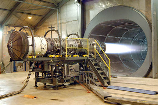 
A Pratt & Whitney F100 turbofan engine for the F-15 Eagle and the F-16 Falcon being tested in the hush house at Robins Air Force Base, Georgia, USA. The tunnel behind the engine muffles noise and allows exhaust to escape