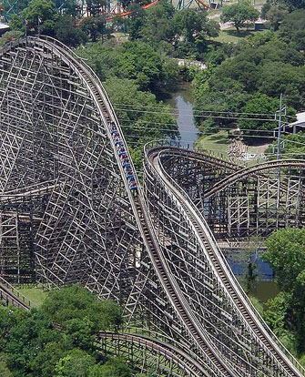 
The cars of a roller coaster reach their maximum kinetic energy when at the bottom of their path. When they start rising, the kinetic energy begins to be converted to gravitational potential energy. The sum of kinetic and potential energy in the system remains constant, assuming negligible losses to friction.