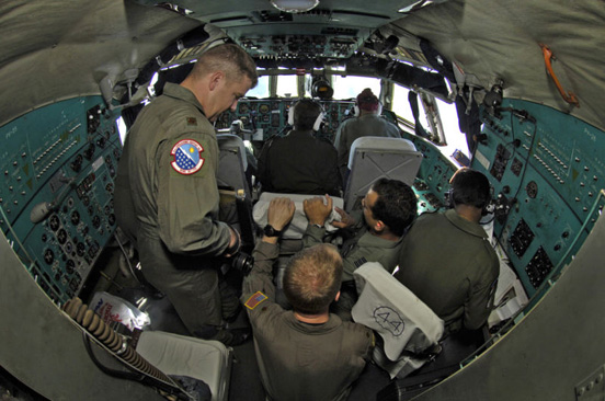 
USAF and IAF airmen work inside the cockpit of an Indian Il-76.
