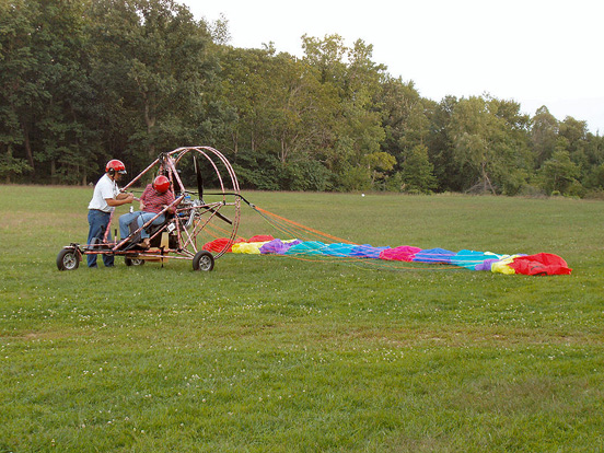 
A powered parachute with its wing laid out in preparation for takeoff.