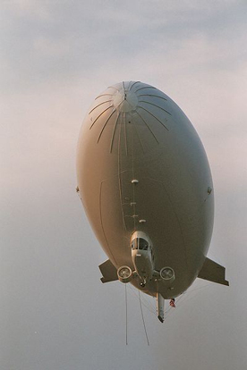 
A modern blimp from Airship Management Services showing a strengthened nose, ducted fans attached to the gondola under the hull, and cable-braced fins at the tail