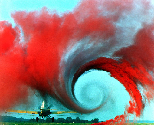 
A vortex is created by the passage of an aircraft wing, revealed by smoke. Vortices are one of the many phenomena associated to the study of aerodynamics. The equations of aerodynamics show that the vortex is created by the difference in pressure between the upper and lower surface of the wing. At the end of the wing, the lower surface effectively tries to 'reach over' to the low pressure side, creating rotation and the vortex.