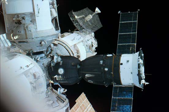 
A Space Shuttle Atlantis out-the-window view showing a Soyuz spacecraft docked with Mir