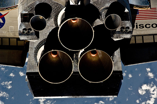 Tail-end of an orbiter showing various nozzles during an orbital maneuver with ISS
