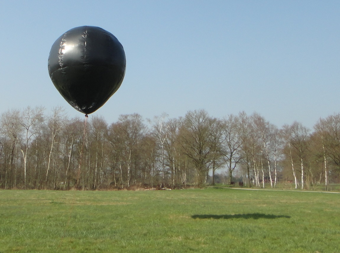 A 4 meters high solar balloon floats over a meadow.
