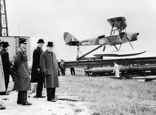 Winston Churchill and others waiting to watch the launch of a de Havilland Queen Bee target drone, 6 June 1941