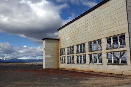 
Old hangar, plane, and mountains