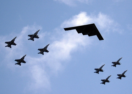 A B-2 in formation flight with eight U.S. Navy F/A-18 Hornets and Super Hornets