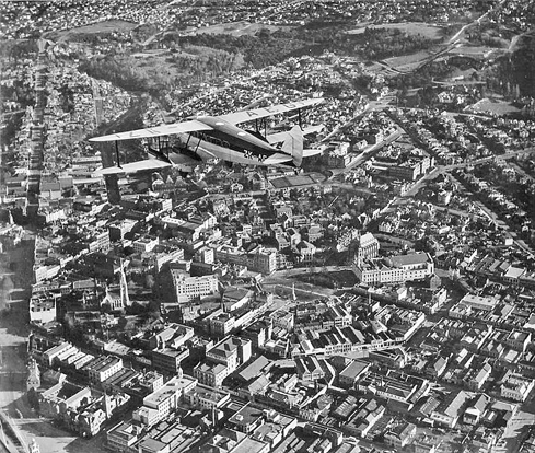 
A Union Airways of New Zealand de Havilland D.H.86 flies over Dunedin.