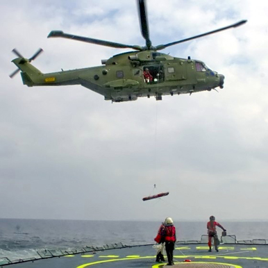 
A Royal Danish Air Force AW101 hoisting from a ship's deck
