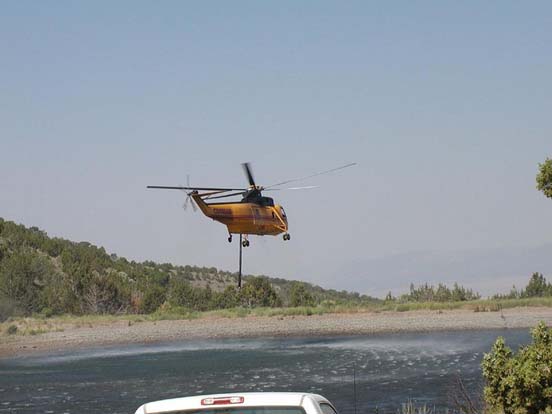 
An S-61 helitanker uses a snorkel to refill its internal water tanks