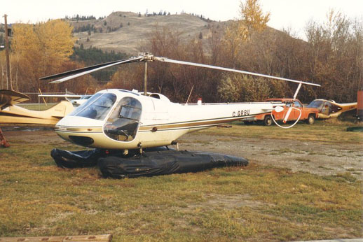 
An Enstrom F-28C on inflatable floats with a scrapped Enstrom in the background, 1986