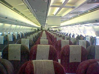 
Interior of a Qatar Airways Airbus. Video systems (the vertical white panels) are visible above the very centre seats of the aircraft