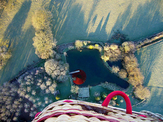 
Taken from the basket, the reflection of the balloon can be seen in the lake below. Obstacles in the landscape can inhibit smooth retrieval of the balloon upon landing.