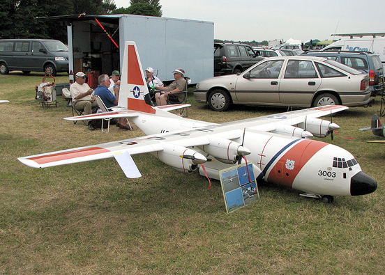 
A very large US Coast Guard C-130J Hercules flying model. The wingspan is 18 feet 6 inches (5.6 m). The crew of five who fly and maintain it are in the background.
