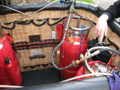 
Stainless steel fuel tanks, wrapped in red insulating covers, mounted vertically, and with fuel gauges, during refueling